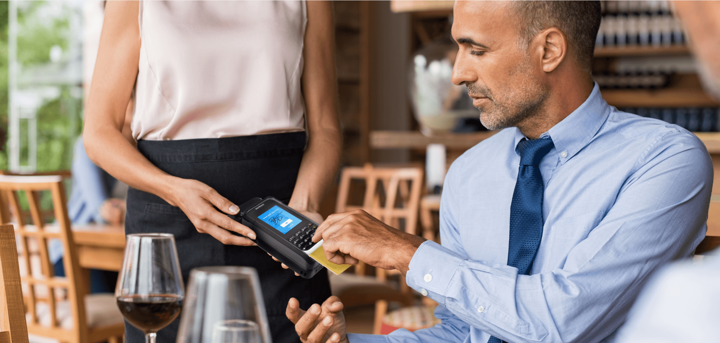 Uomo che utilizza una custodia mPOS per completare il pagamento in un ristorante.