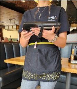 Dipendente di Denny's con dispositivo portatile in mano