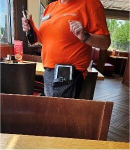 Dipendente di Denny's con dispositivo portatile in mano