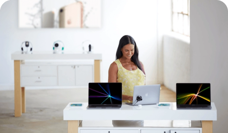 Donna che guarda i laptop su un tavolo in un negozio di telefonia mobile
