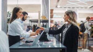 Un addetto alla vendita che gestisce un reso presso il banco del punto vendita, a dimostrazione dell'importanza delle procedure di verifica dei resi per prevenire i resi fraudolenti e le perdite di magazzino.