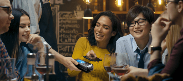 Gruppo di persone sedute con bicchieri di vino e mPOS
