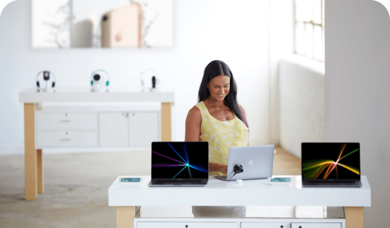Donna che guarda i laptop su un tavolo in un negozio di telefonia mobile