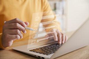 Un responsabile di negozio completa una checklist per la verifica della prevenzione delle perdite su un computer portatile.