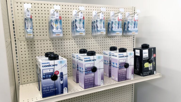 Prodotti per la cura della persona, come spazzolini elettrici o rasoi elettrici, contenuti in scatole protette da sistemi di sicurezza.