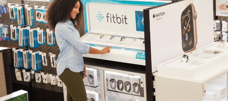 Donna davanti al display Fitbit in un negozio al dettaglio