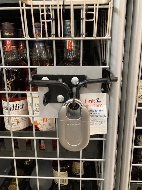 Padlock le bottiglie di liquore in una gabbia in un negozio Meijer