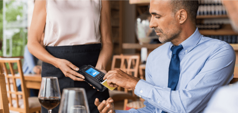Uomo che utilizza una custodia mPOS per completare il pagamento in un ristorante.
