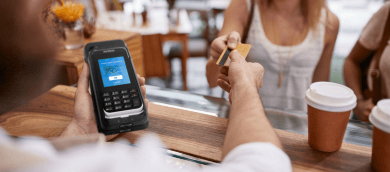 Donna che tiene in mano mPOS  NE360H e restituisce la carta di credito al cliente