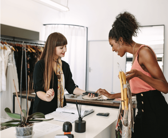 Donna che tiene in mano dei vestiti e paga con mPOS  NE360H