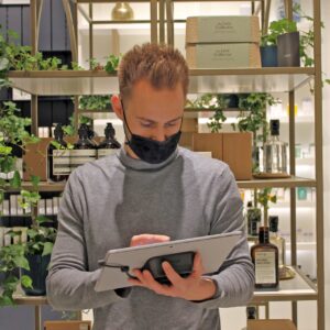 Uomo con maschera che tiene un supporto per tablet mobile